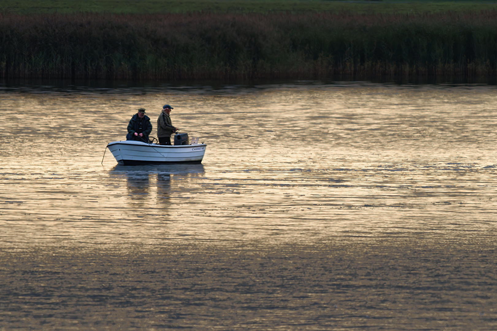 Angler im goldenen Bodden am frühen Morgen