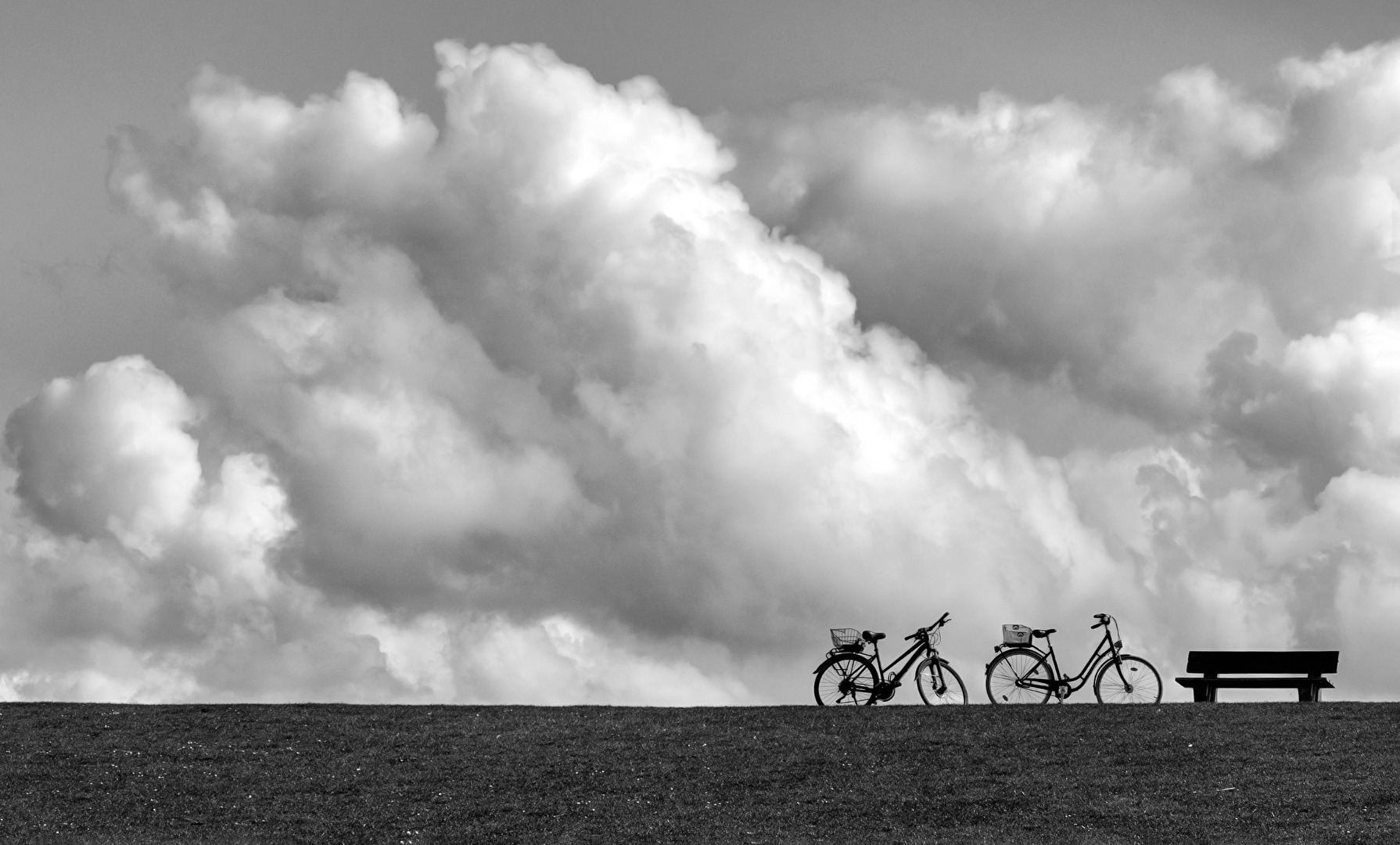 Wolken, Fahrraäder und Bank