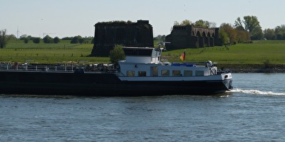 Frachtschiff vor historische Eisenbahnbrücke
