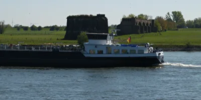Frachtschiff vor historische Eisenbahnbrücke